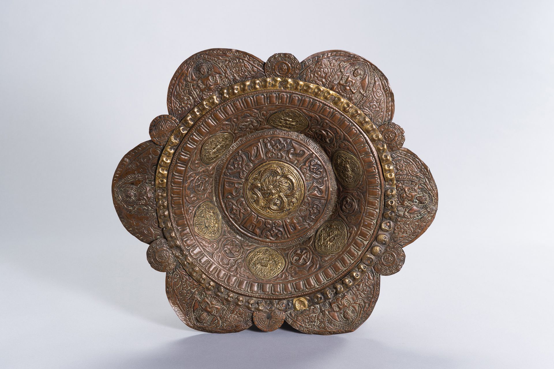 A LARGE COPPER REPOUSSE ALMS DISH 一个大型的铜制repousse ALMS盘
藏族-中国，19世纪。裂开的铜盘由许多部分铸成，&hellip;