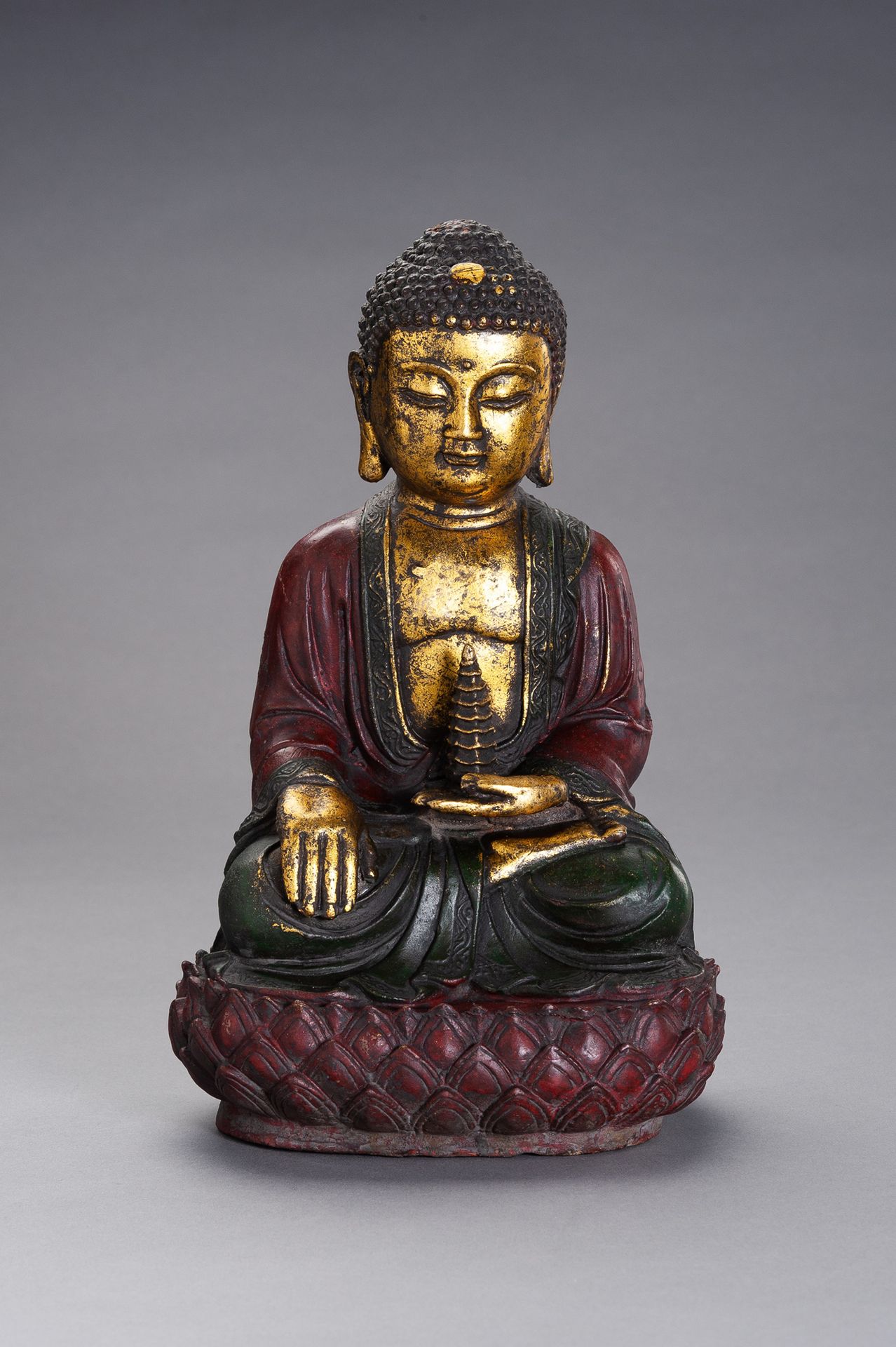 A MING STLYE BRONZE FIGURE OF BUDDHA 明朝铜佛像
中国，20世纪。铜像上涂有多色珐琅彩，包括黄金。菩萨坐于未封口的莲花底座上&hellip;