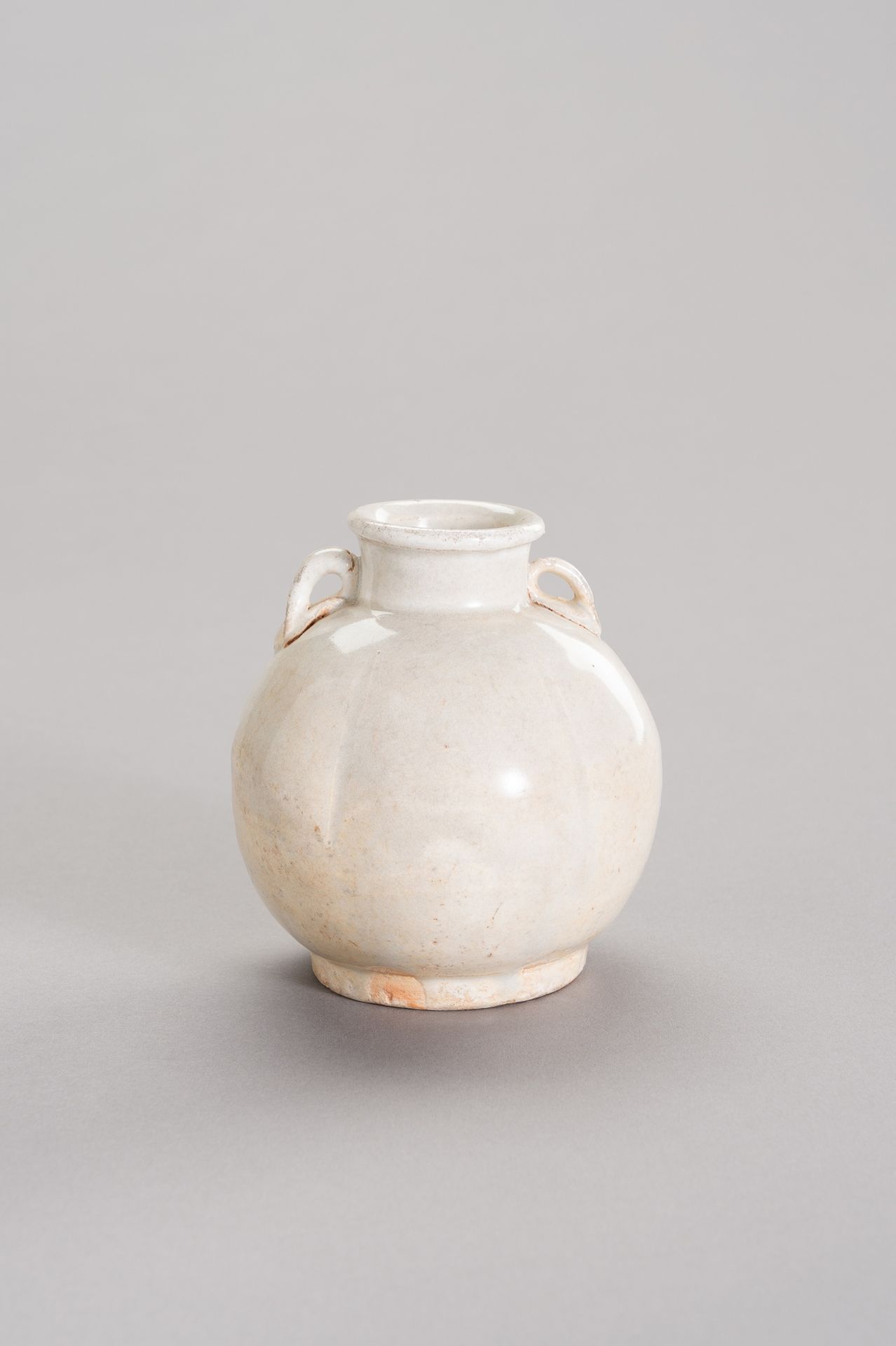 A MELON-SHAPED, WHITE-GLAZED CERAMIC JARLET 瓜子形白釉陶瓷罐
中国，北宋，11-12世纪。圈足，厚唇，颈部有两个耳，&hellip;