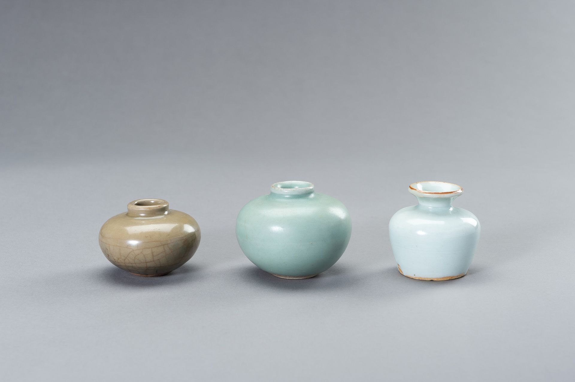 THREE SMALL CELADON GLAZED JARS 三个小型青瓷釉罐
中国，明朝（1368-1644）。一个球状，短颈，浅蓝色的亚光青瓷釉。一件为球&hellip;