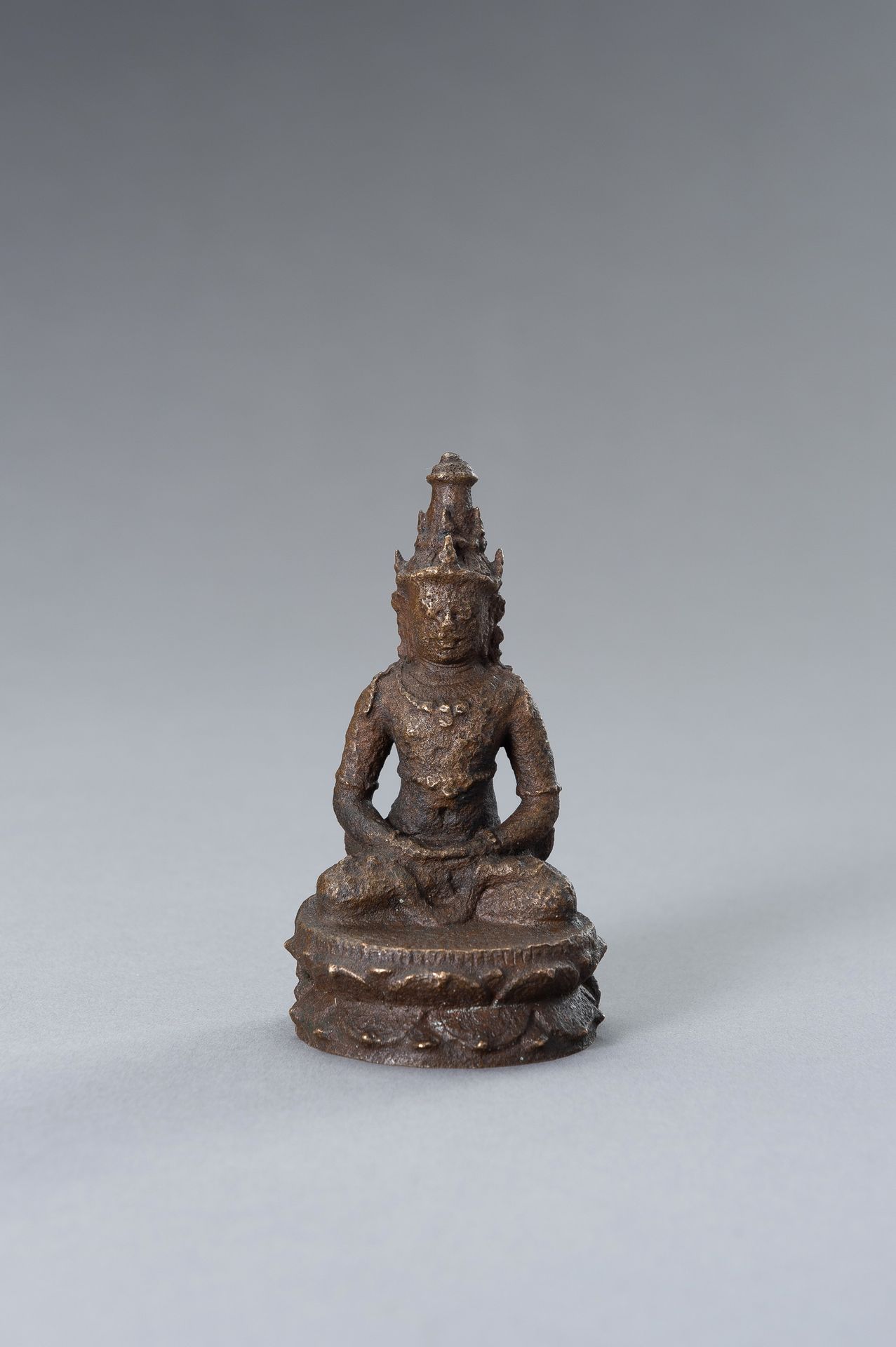 AN INDONESIAN BRONZE FIGURE OF BUDDHA 印度铜佛像
爪哇，10世纪的风格，但可以追溯到19世纪。坐在有珠边的双莲座上，双手合&hellip;