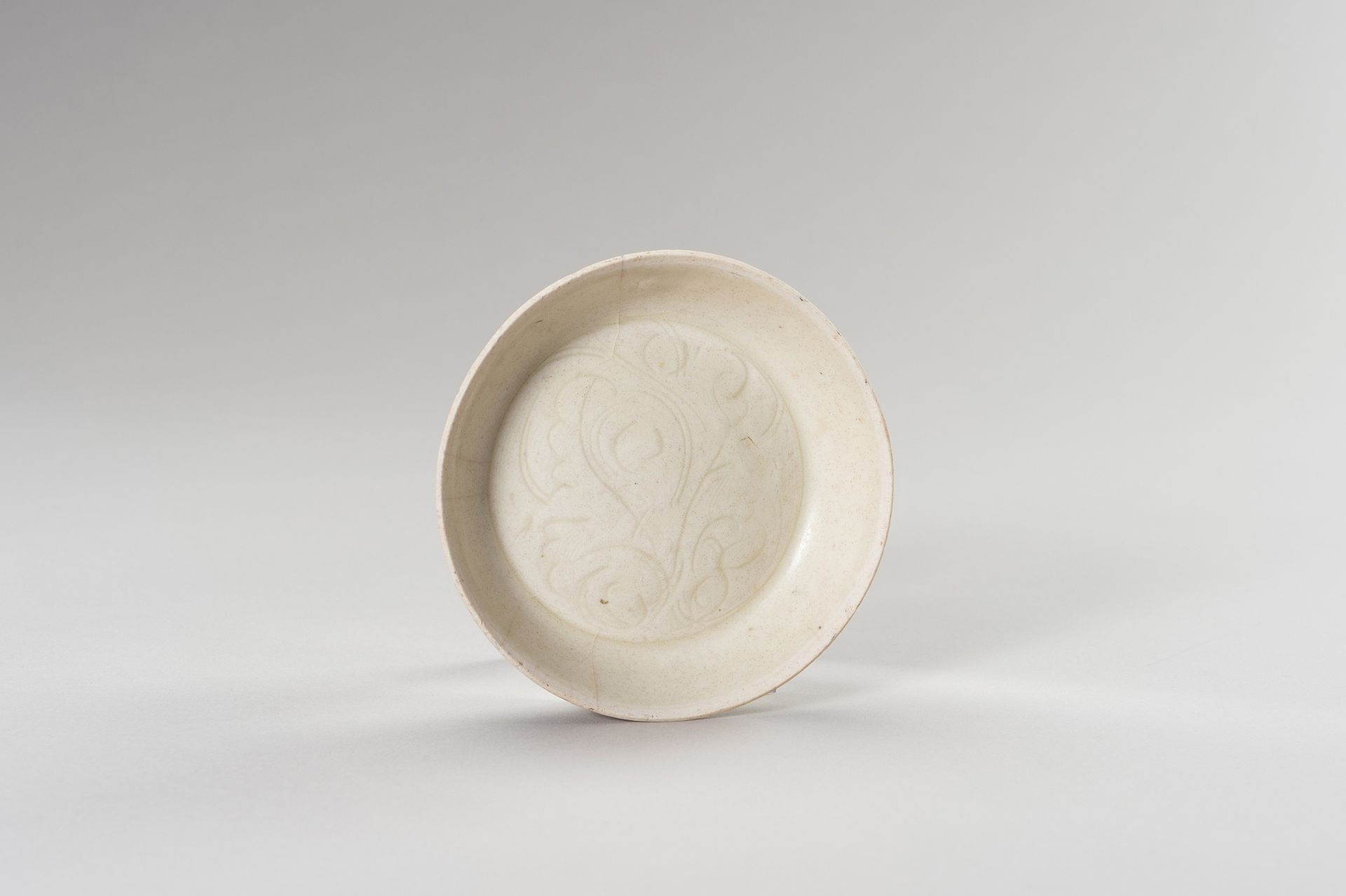 A SMALL QINGBAI ‘PEONY’ PORCELAIN DISH 一个小型的清白 "牡丹 "瓷盘
中国，北宋（969-1127）。盘子有一个平底，两&hellip;