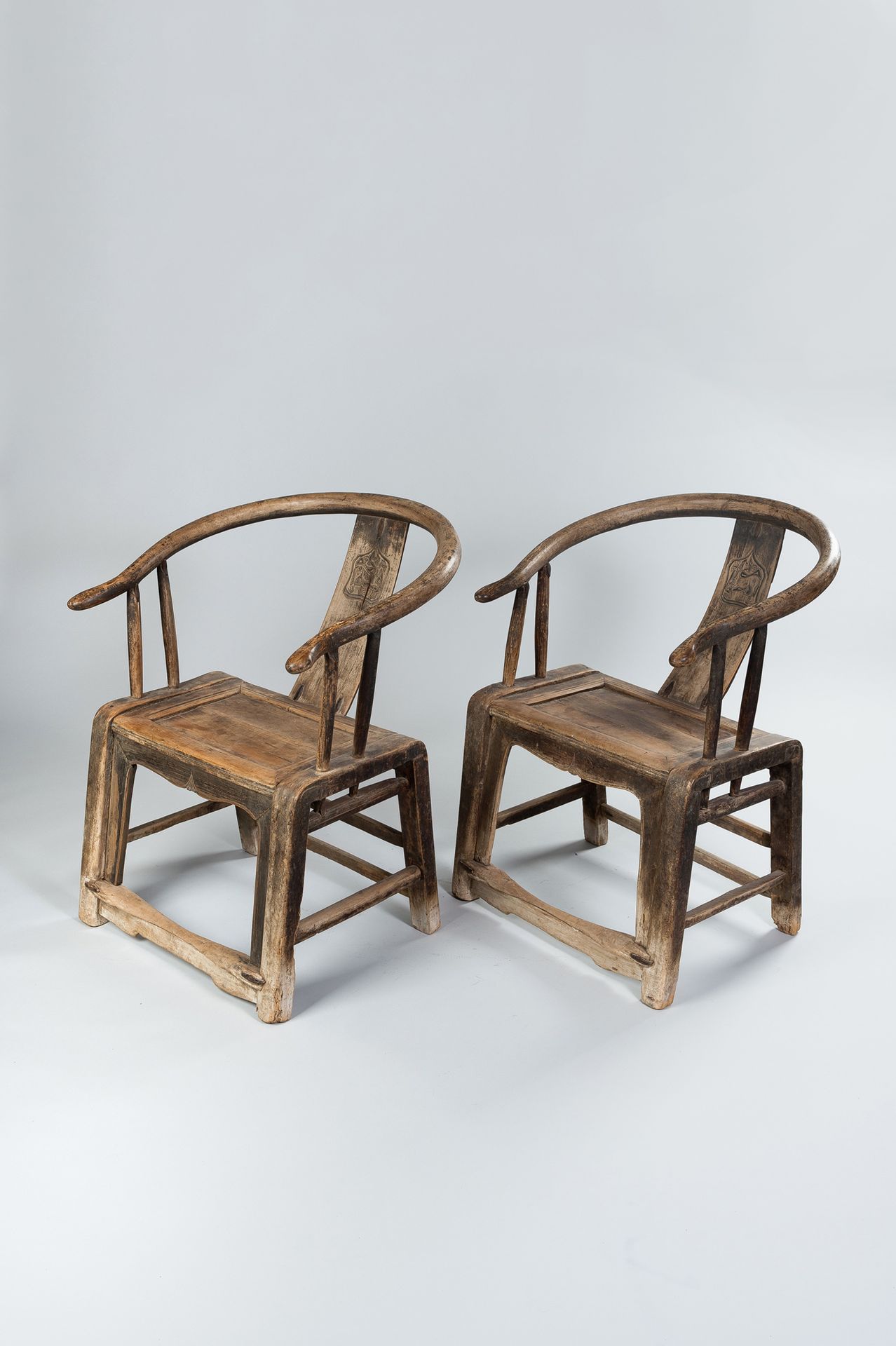 A PAIR OF HORSESHOE WOOD CHAIRS 一对马蹄铁木椅
中国，清朝（1644-1912）。椅背上有弯曲的顶轨和宽大的长方形木板，雕刻着一&hellip;