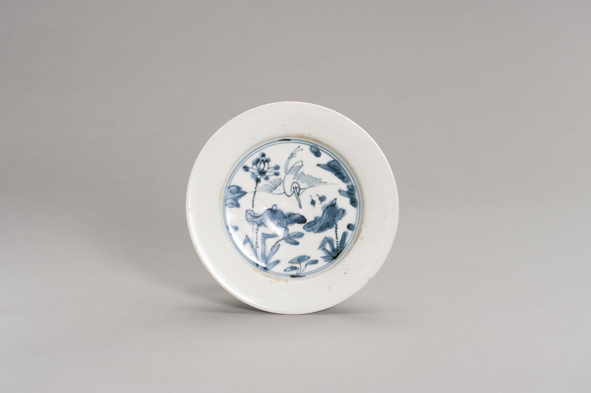 A BLUE AND WHITE PORCELAIN DISH WITH A CRANE 一个青花瓷碟子，上面有一个CRANE
中国，明末（1368-1644）&hellip;