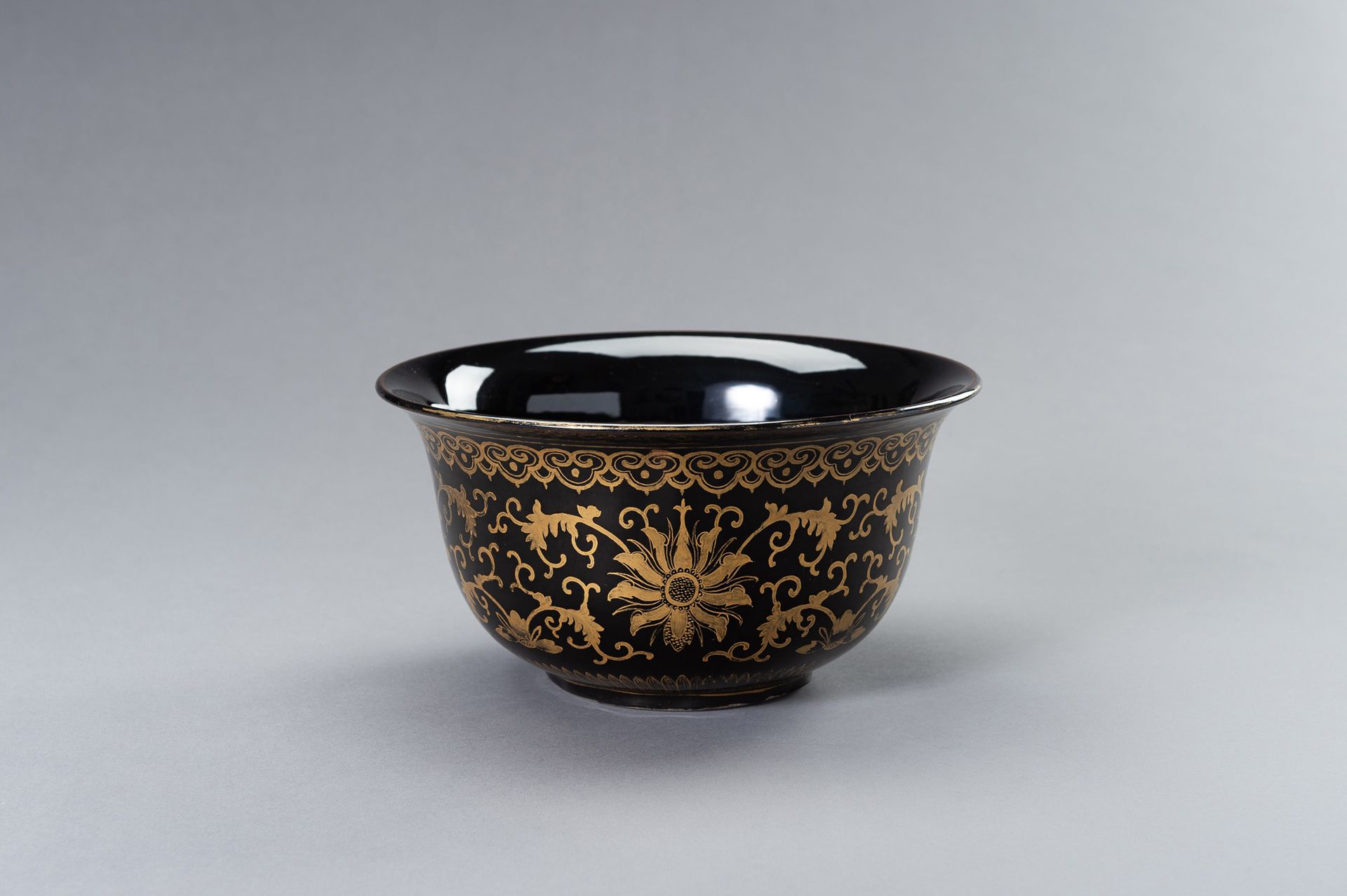 A LARGE BLACK AND GOLD PORCELAIN BOWL 一个巨大的黑金瓷碗
中国，清末（1644-1912）。深圆的侧面从短底上升到轻柔的边&hellip;