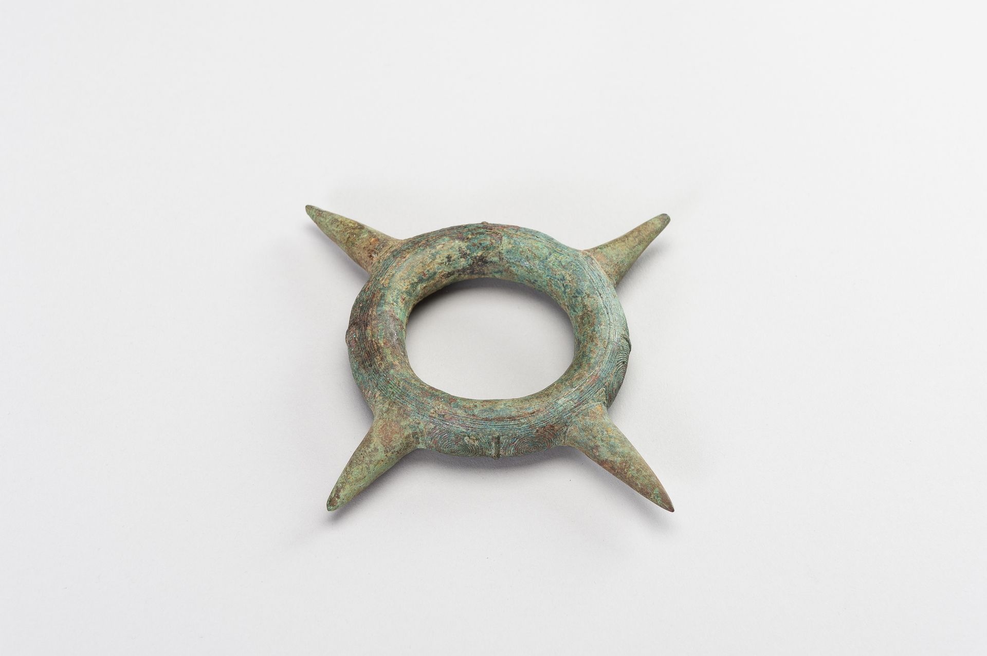 A BRONZE BANGLE WITH SPIKES 带钉子的青铜手镯
中国南部/越南北部，东桑文化（公元前800年-公元200年）。铸有四个长钉，刻有典型的&hellip;