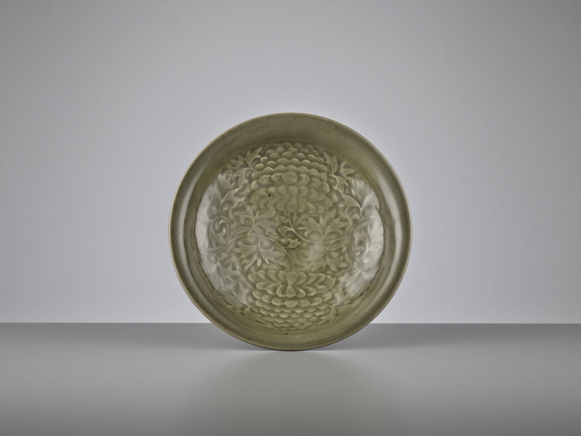 A YAOZHOU CELADON CARVED ‘PEONY’ SHALLOW BOWL, NOTHERN SONG DYNASTY 一件耀州瓷雕 "牡丹 "&hellip;