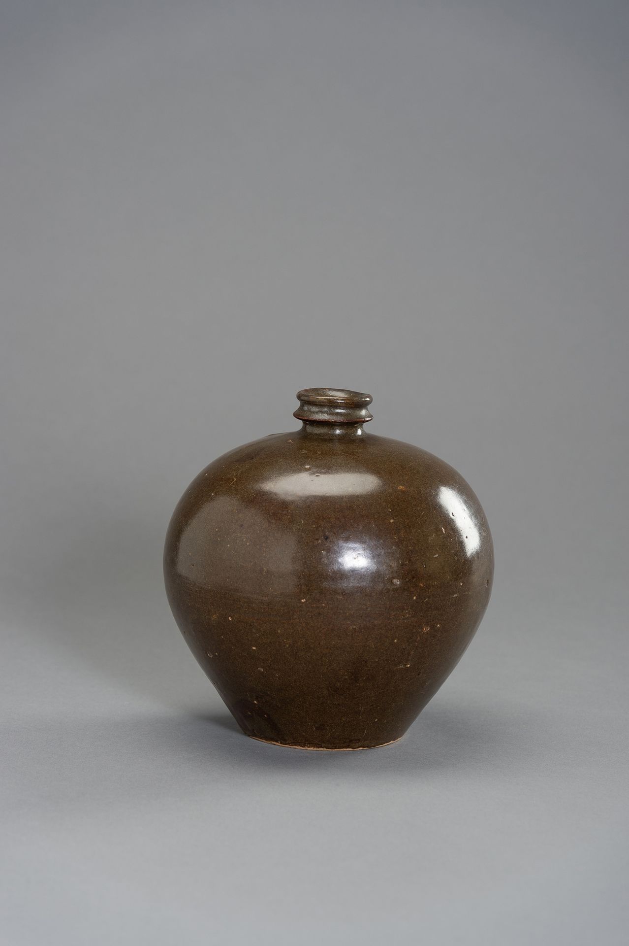 A HENAN BROWN GLAZED BOTTLE VASE 河南棕色釉面瓶
中国，宋代（10-13世纪），河南省。卵形的陶瓷花瓶上有均匀的棕色釉。

状况&hellip;