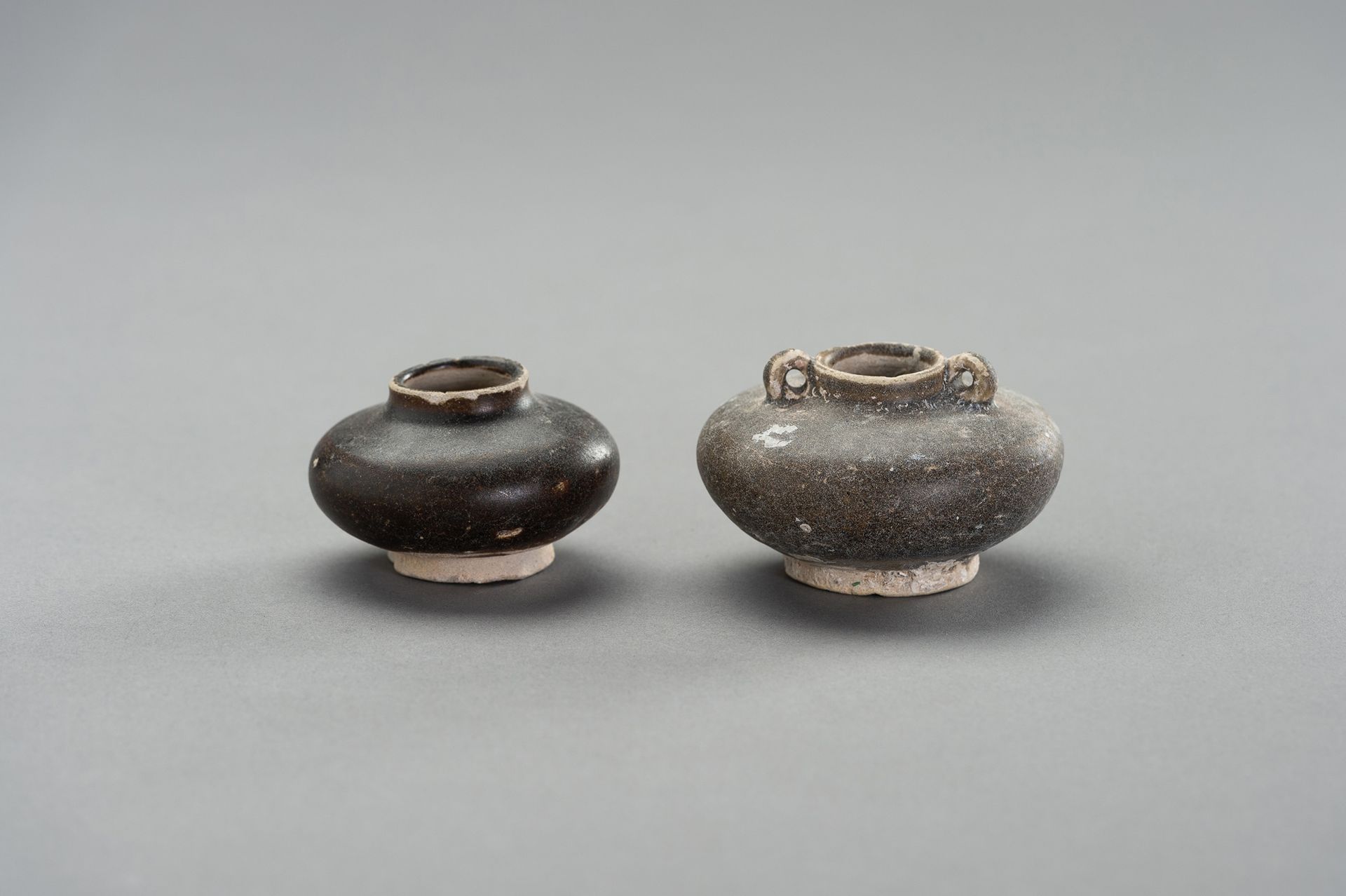 TWO GLAZED CERAMIC ´SHIPWRECK´ POTS 两件釉面陶瓷"船舱"壶
中国南方，12-14世纪。

状况：两件棕色釉陶罐，环形底座，球&hellip;