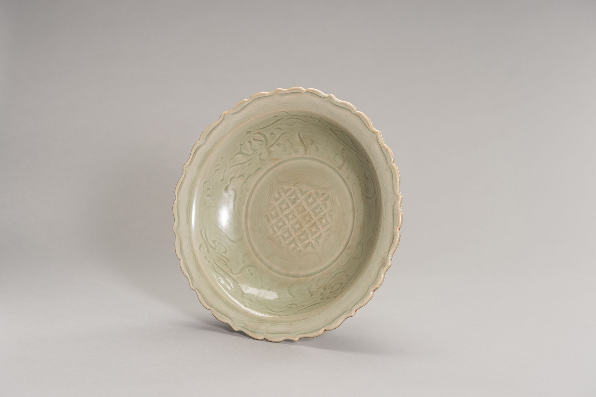 A LARGE LONGQUAN CELADON BARBED-RIM PLATE 大型龙泉青花瓷带刃盘
中国，明朝（1368-1644）。盘子内壁中央刻有凹陷&hellip;