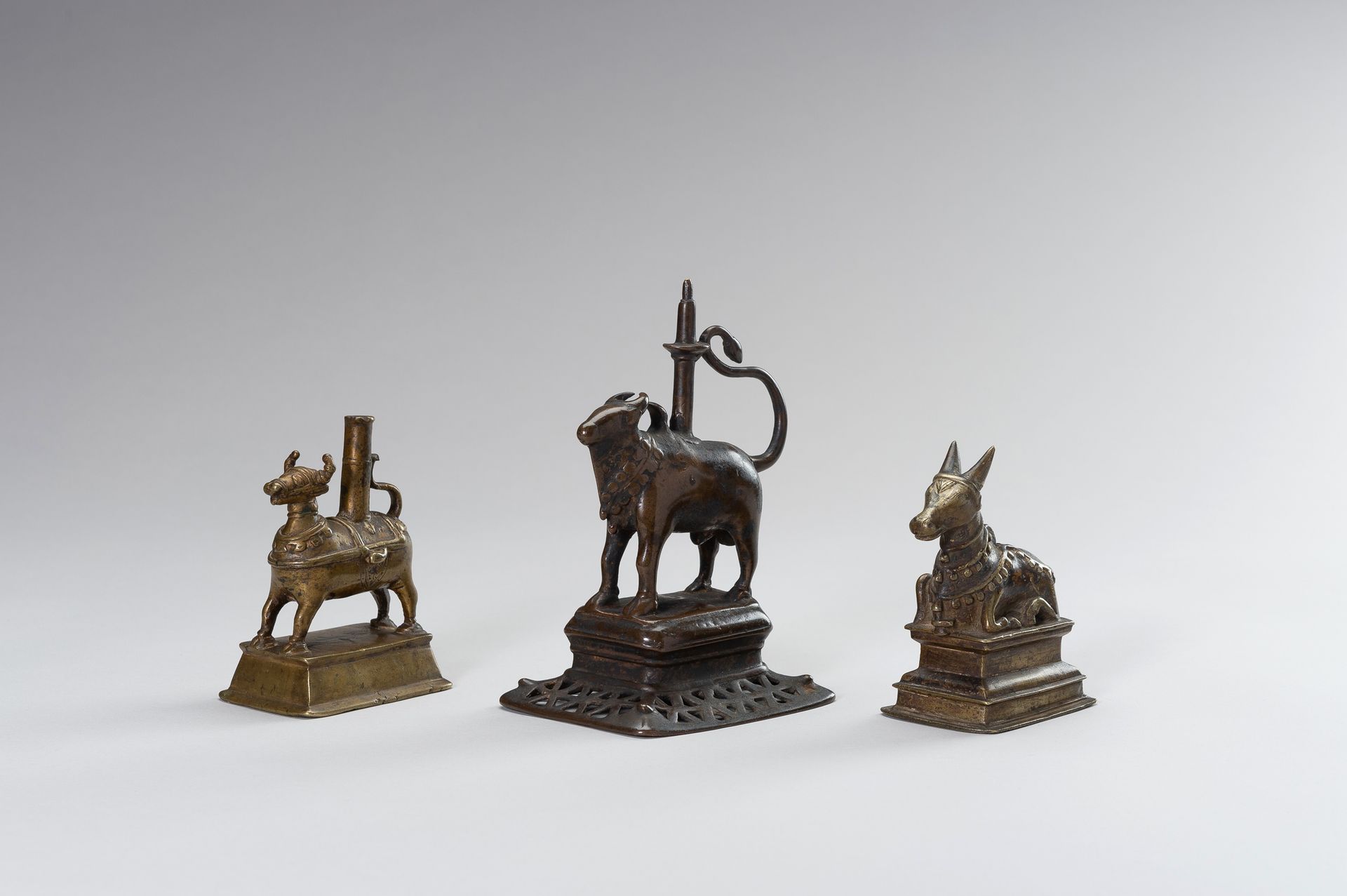 A GROUP OF THREE BRONZE FIGURES OF NANDI 一组三个南帝的铜像
印度，17至18世纪。第一和第二尊铜像站在一个长方形的平台&hellip;