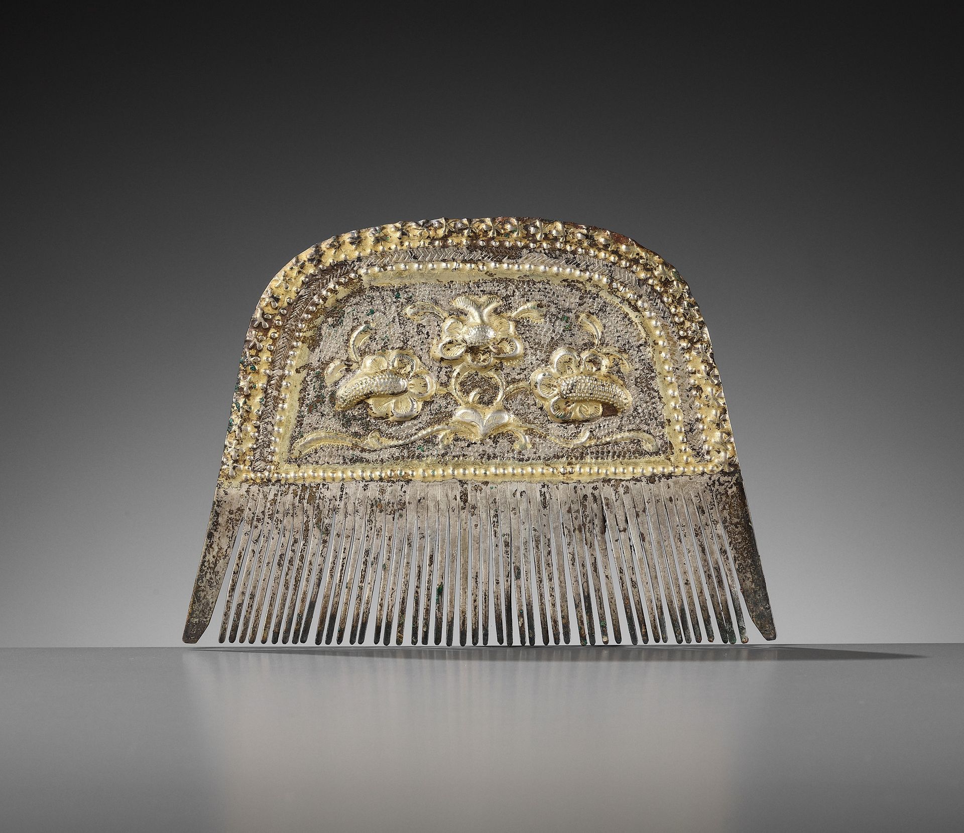 A PARCEL-GILT SILVER COMB, TANG DYNASTY 一把唐代鎏金银梳子
中国，618-907。梳子上部的鎏金部分用回形纹装饰，梅花从&hellip;
