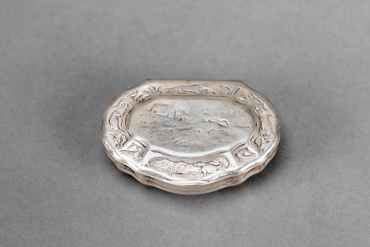 Null 银质鼻烟盒，马蹄形，有一个盖子，刻有狩猎场景的装饰，有两个印记，里面镀了金，48克。