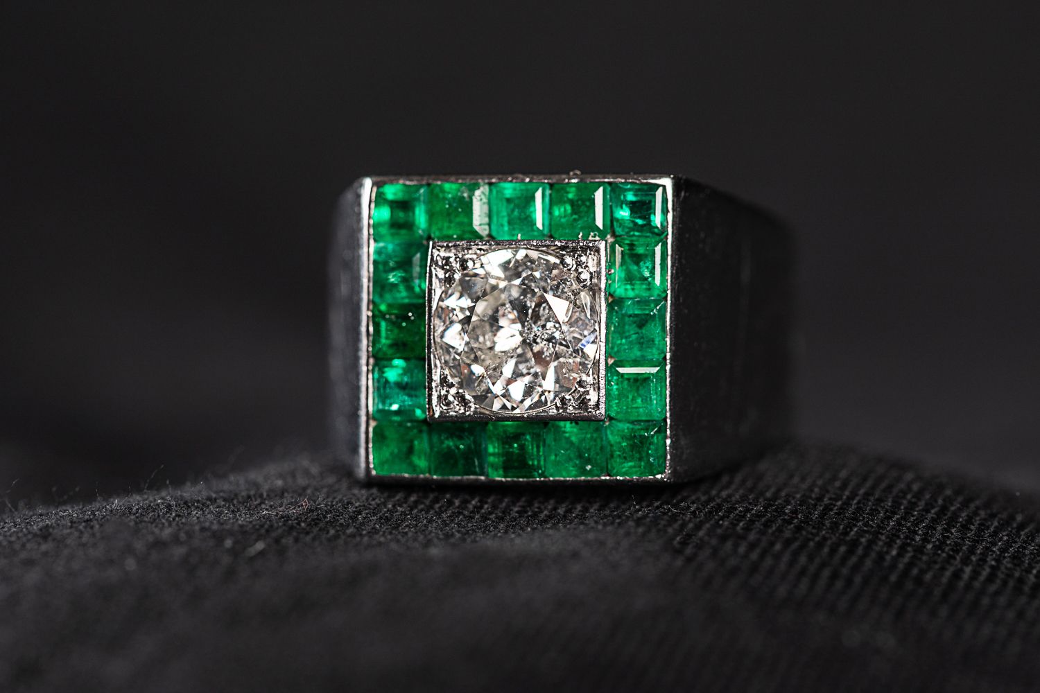Null 750白金戒指，镶有绿宝石和一颗1.5克拉的中央钻石，颜色为F。