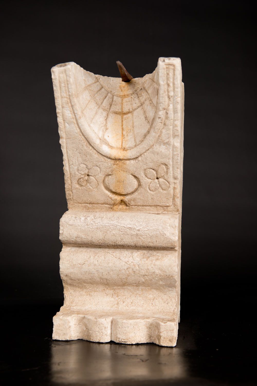 Stone Sundial 石制日晷，圆柱形，呈阶梯状和弓形，有半圆形的顶部和刻度；白色白垩石，有生锈的铁制顶盖；已风化，可能是18世纪。高46厘米。