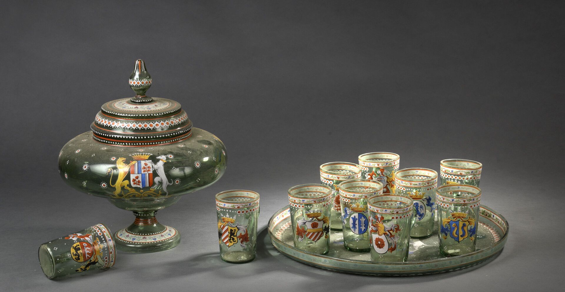 Null 珐琅彩玻璃打孔器，19世纪末德国作品

它包括十个有柄高脚杯，一个托盘，一个有盖的壶

饰有纹章。

小事故。

H.30厘米