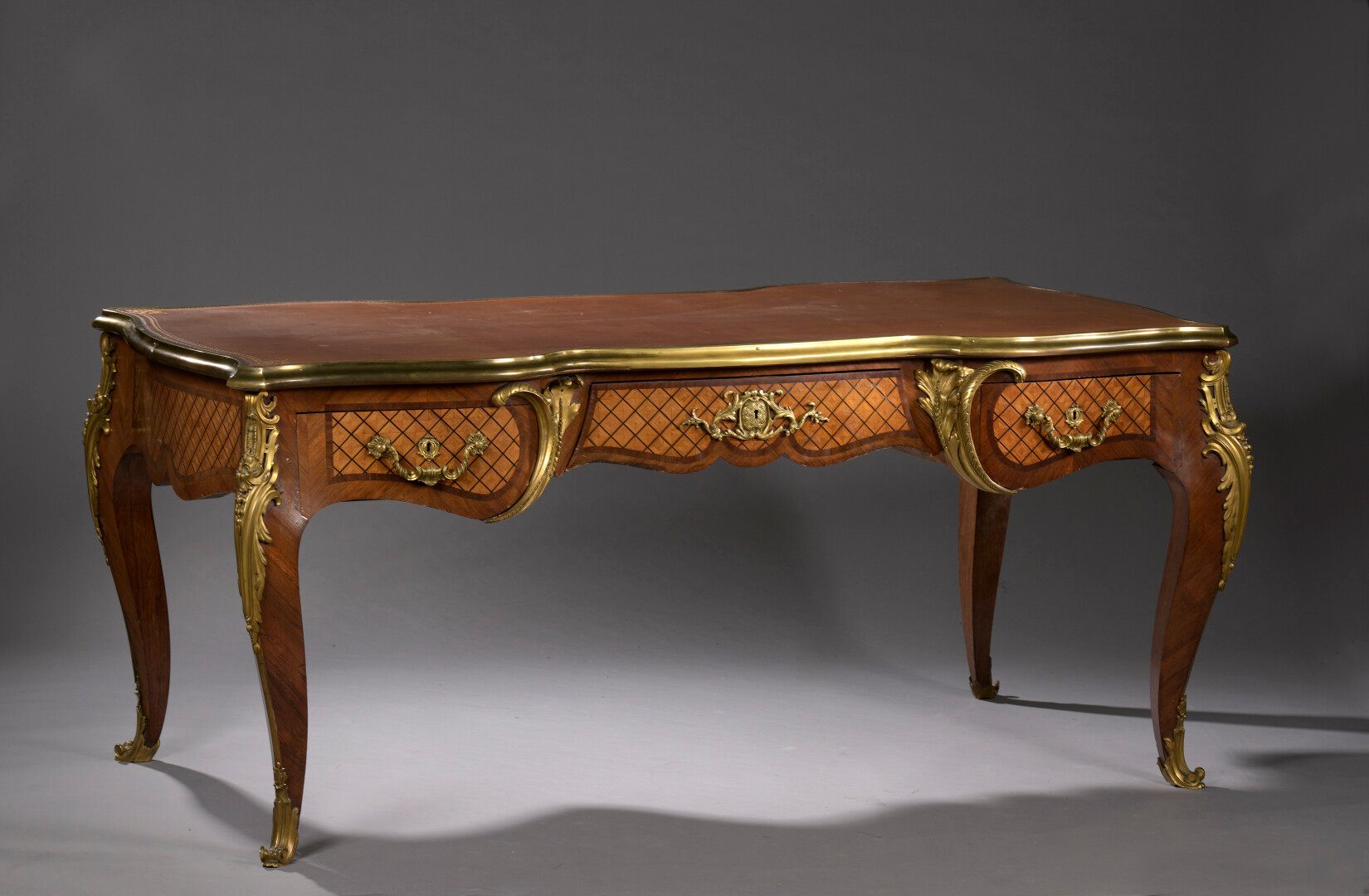 Null 路易十五风格的紫檀木饰面和苋菜框架的平桌，约1900年

书桌的腰部有三个抽屉，在乌木背景上装饰着十字架，放在四个拱形的腿上。

丰富的装饰品是由铜器&hellip;