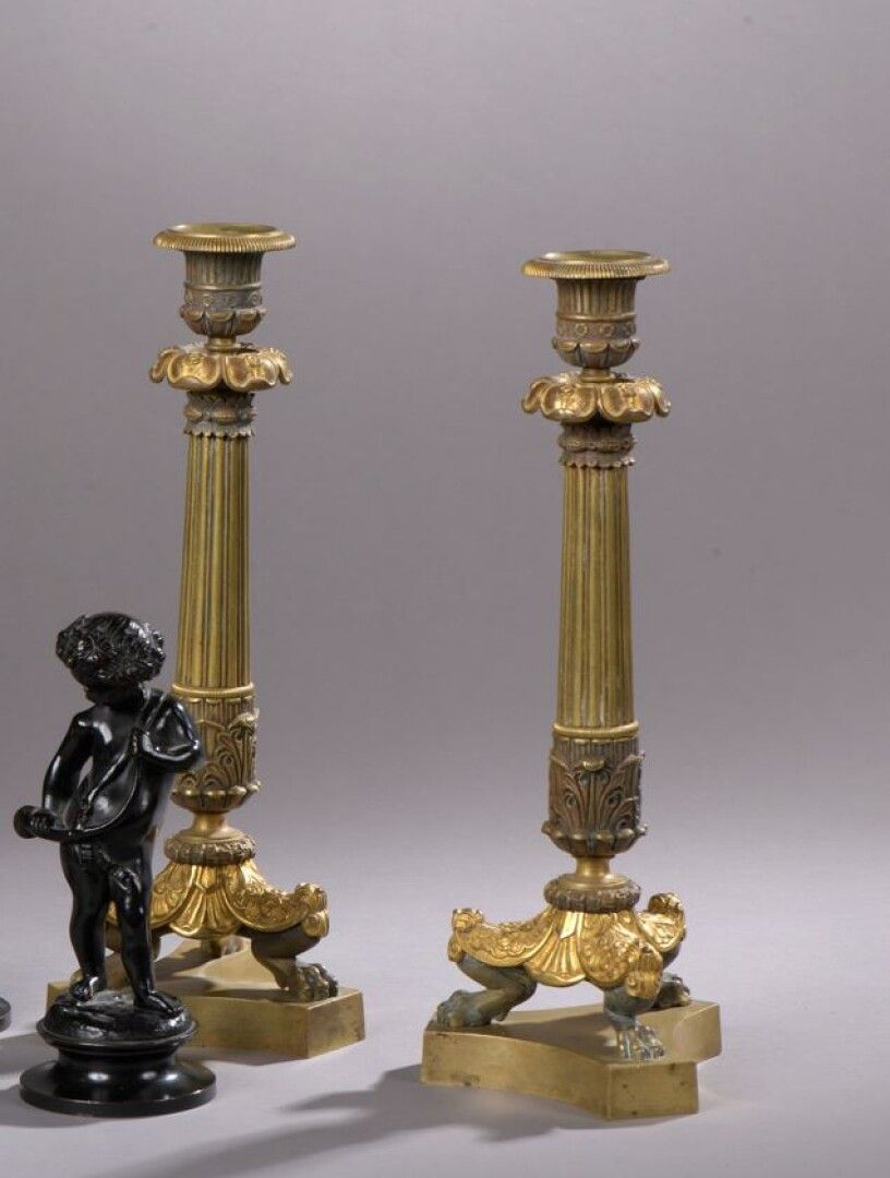 Null 一对路易-菲利普时期的带花纹和镀金的青铜烛台

有凹槽的轴，它们站在一个有爪子的底座上。

H.32,5 cm