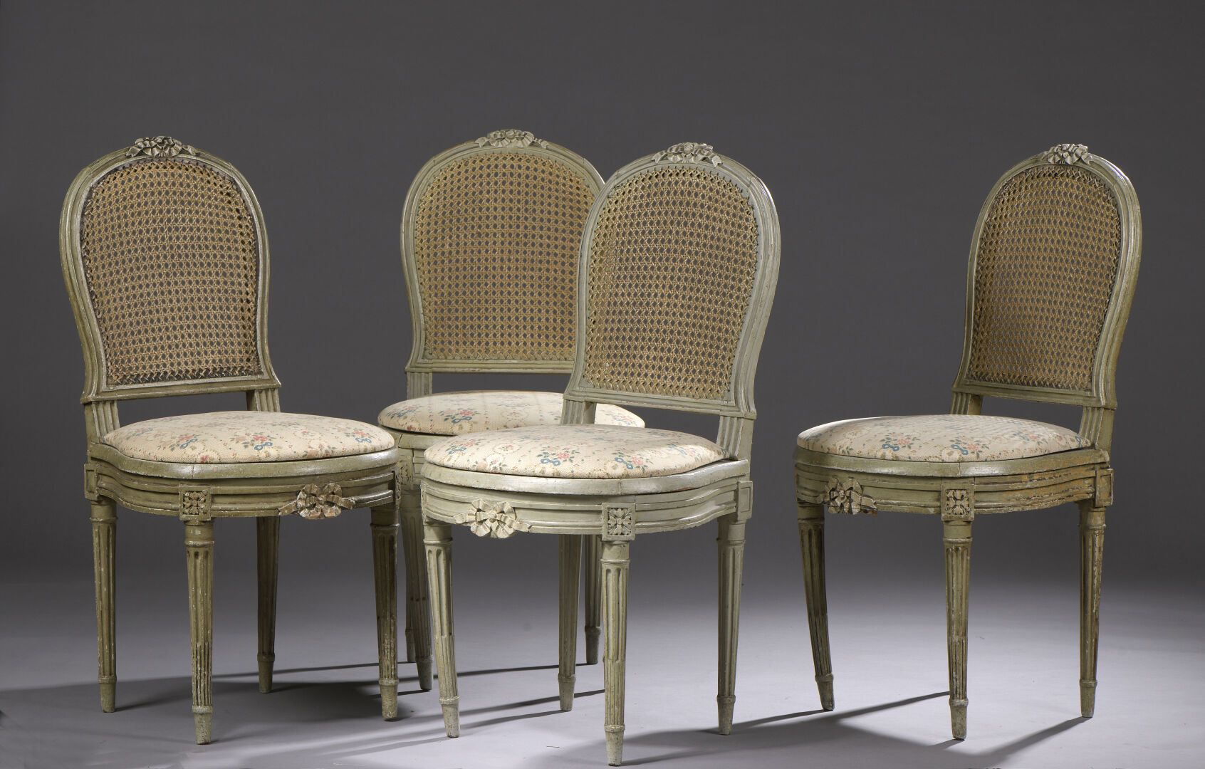 Null 一套四张路易十六时期的雕花和涂漆的木制藤椅。

背部和座位呈马蹄形，装饰有绳结，它们站在四个有凹槽和沟槽的锥形腿上（加固）。

H92 W. 45 D&hellip;