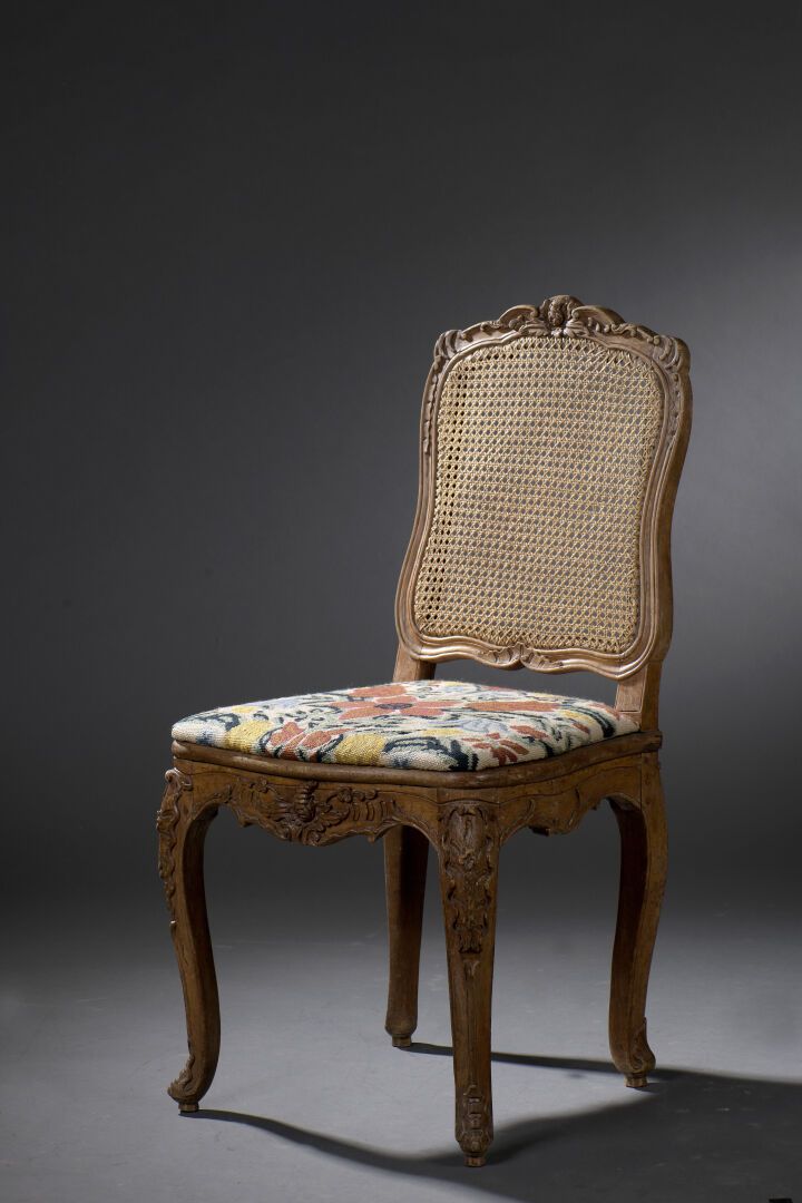 Null 一把路易十五时期的模制和雕刻的木制藤椅，印有L.Cresson。

它有一个弯曲的靠背，靠在雕刻着贝壳、叶子和花朵的弯腿上。

在腿的末端进行修复。
&hellip;