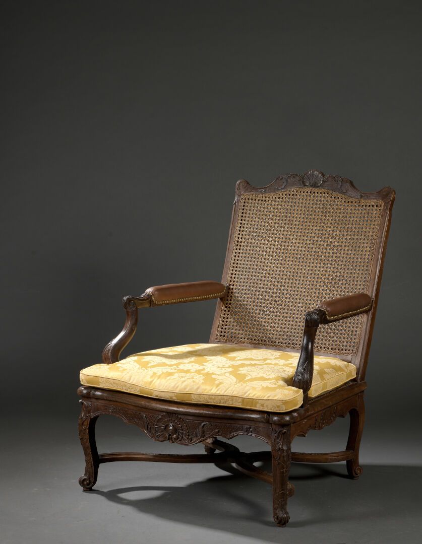 Null 路易十五风格的大型模制和雕刻的木制低杖扶手椅

它有一个弯曲的藤条靠背，靠在由一个X形支架连接的拱形腿上。

H.100 W.78 D.67 cm