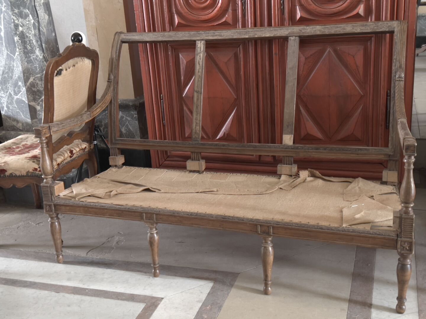 Null Directoire风格的模制和雕刻的木制沙发。

有一个反转的靠背，栏杆式扶手，它靠在栏杆式的脚上，前面是环，后面是马刀。 

装饰有星星和棕榈花
&hellip;