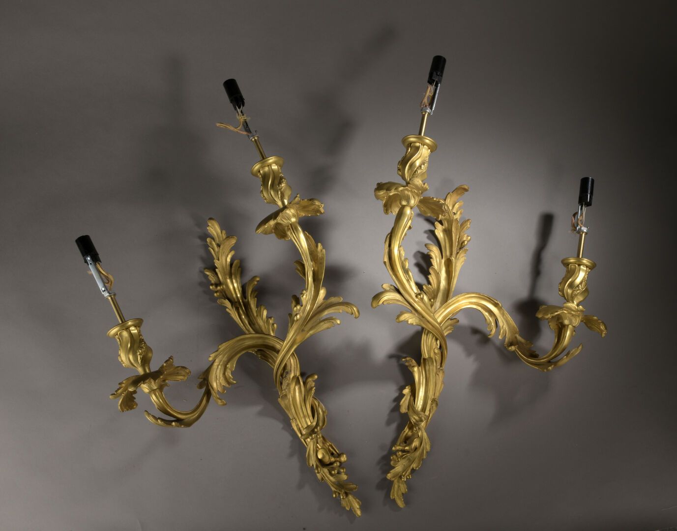 Paire d'appliques en bronze doré, de style Louis XV 一对路易十五风格的木制壁炉，两只灯臂上装饰着树叶。

电&hellip;