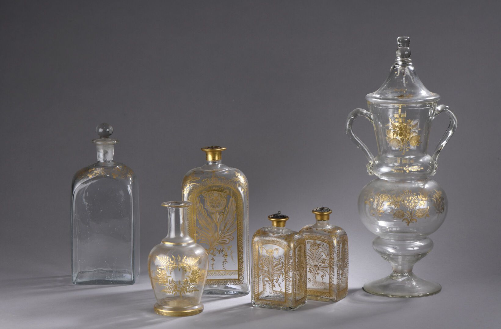 SUITE DE TROIS FLACONS en verre - Fin du XVIIIe siècle. 一套三件黄金和雕刻的玻璃瓶，装饰有花束的造型储备&hellip;