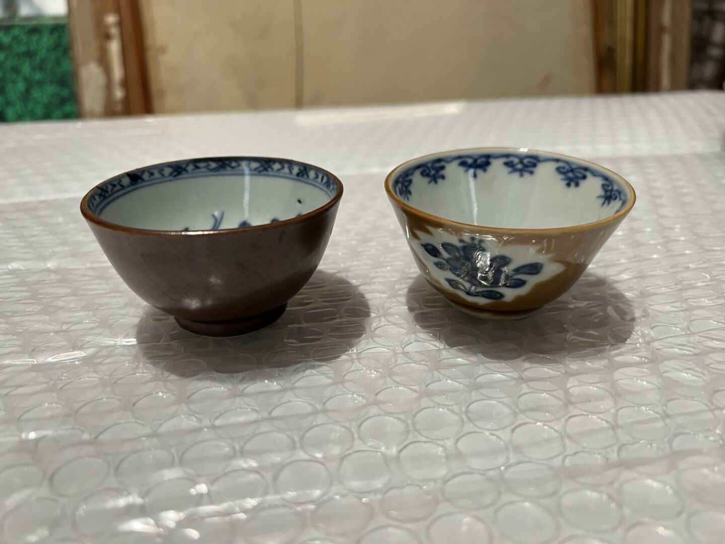 Null 两只青花瓷碗，背景是金莲花
中国，18世纪
饰有花朵和蝴蝶；其中一个有裂纹
D.7.5厘米