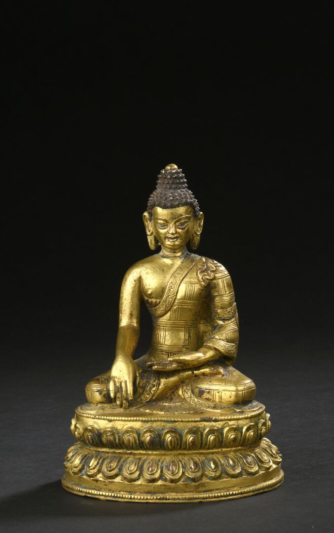 Null 镀金铜佛像
尼泊尔，19世纪末/20世纪初 
身着僧袍，头发卷曲并遮盖着乌瑟尼莎，坐在双层莲花形底座上，右手握着布摩斯帕萨穆德，身着僧袍。
H.14.&hellip;