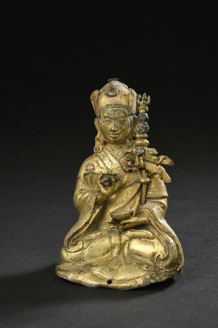 Null 鎏金铜和重塑的莲花生大士雕像
西藏，19世纪
描绘的是坐姿，右手持金刚杵，左手持卡帕拉，左臂和肩膀之间放着哈特万加三叉戟，身穿僧袍，头戴僧帽；氧化和磨&hellip;