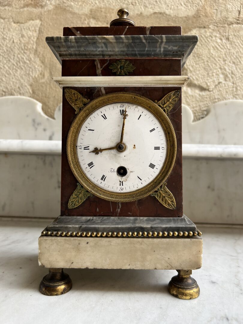 Null 一个白色和粉色大理石、镀金和有凹槽的骨架钟，路易十六时期后期
表盘上有Peltier的签名，装饰着珍珠和棕榈花。
它是用转动的腿站立的。 
H.30厘&hellip;