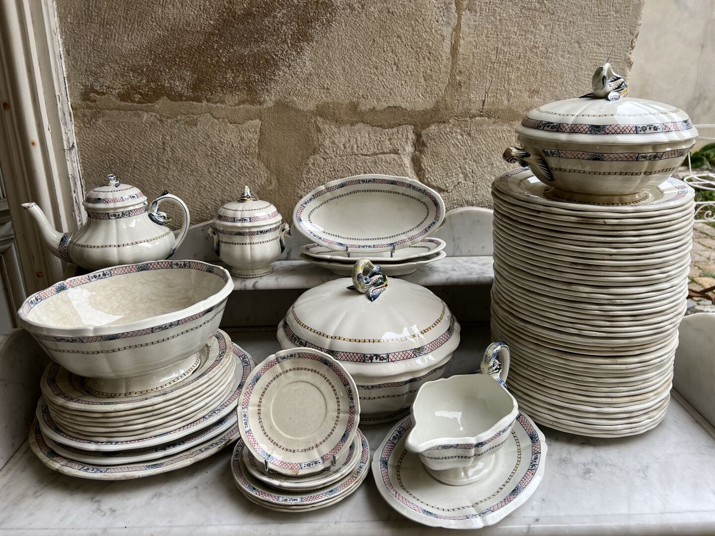 Null 吉恩，1900年左右
鲁昂风格的服务的一部分，陶器，有海豚和浮雕的装饰，包括43个餐盘，碟子和异形件。
D. 26厘米 

一些作品有小的意外。