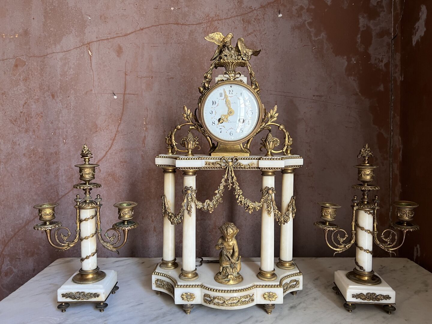 Null 拿破仑三世时期的路易十六风格的白色大理石和鎏金青铜壁炉架 
包括：一个门廊钟，形成了一个寺庙，装饰有花环，采用的是嵌花和鎏金青铜。白色珐琅的表盘上有巴&hellip;