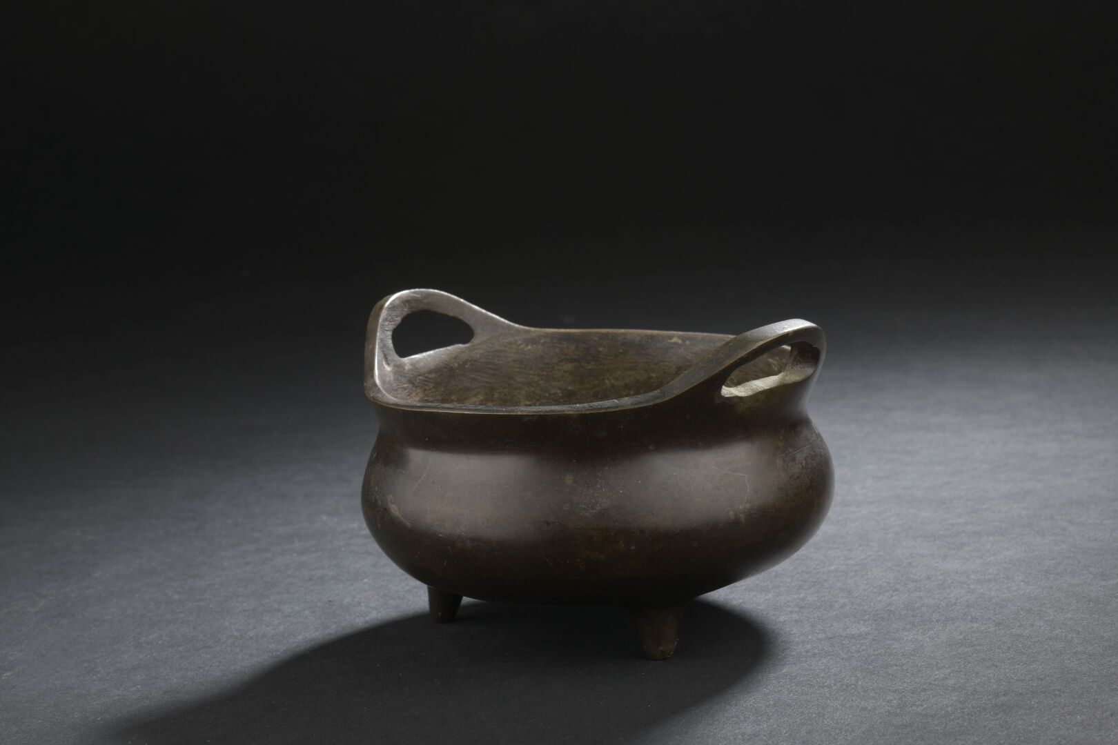 Null 青铜香水炉
中国，清朝(1644-1911)
膨胀的器身，靠在三个小脚上，边框饰有两个把手，底座上有标记。
D. 11厘米