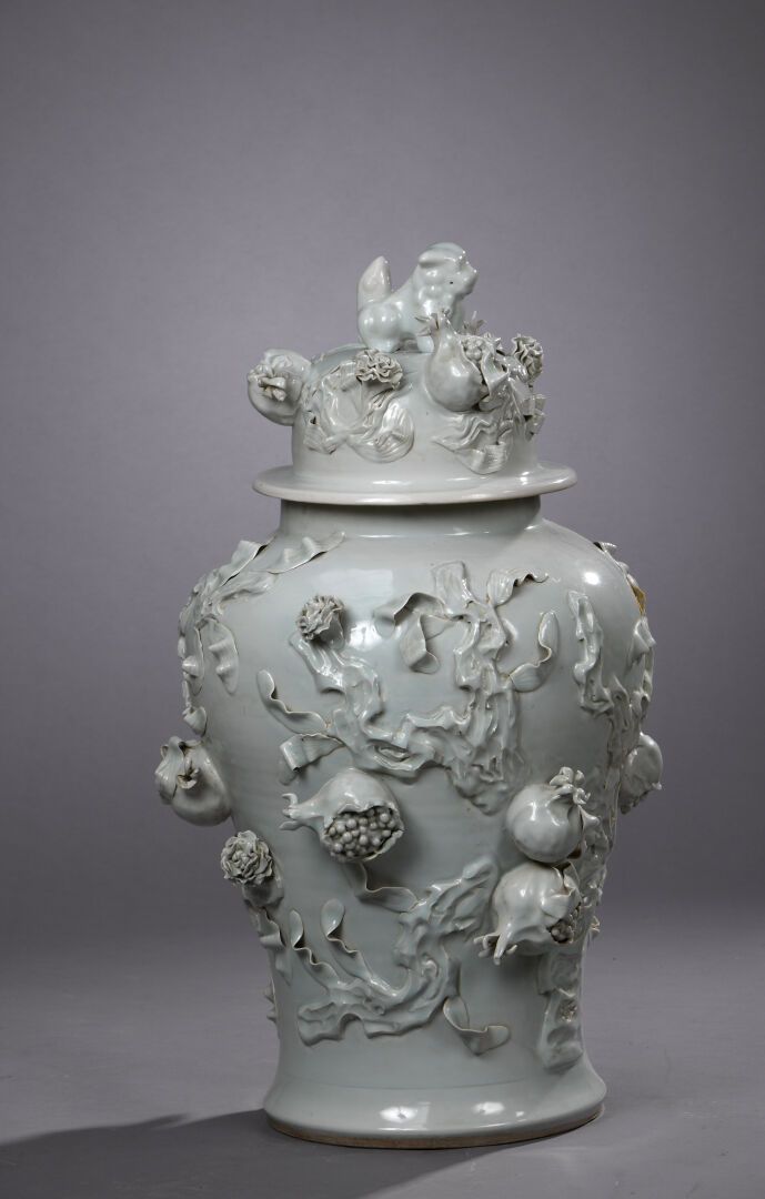 Null 白色珐琅彩瓷器盖罐
中国，19世纪末-20世纪初
阳台，浮雕装饰有石榴和花朵，盖子上有一只佛狗形成的把手。
H.83厘米