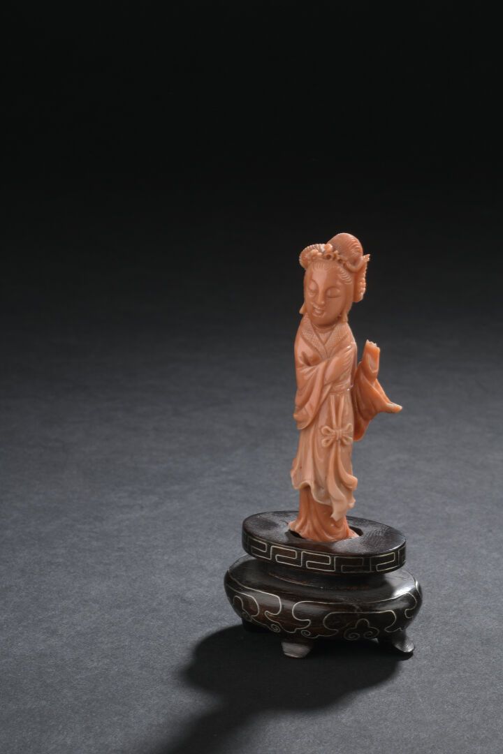 Null 珊瑚雕妇人像
中国
描绘站立的形象，身着长裙，发髻盘起；粘在木质底座上，有两处裂痕。
H.7.5 厘米（不含底座）