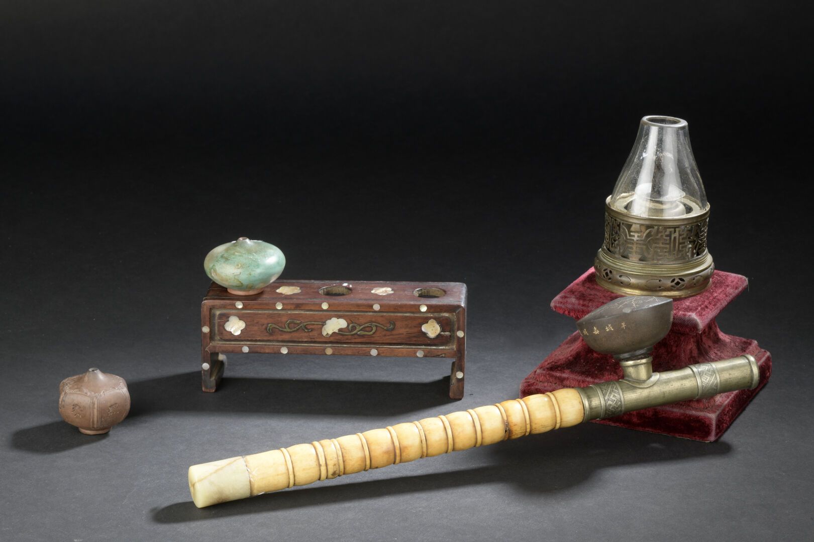 Null 鸦片管和三个炉子
中国，清末（1644-1911）。
骨质和铜质的烟斗，石质的炉子；支架和一盏灯是连在一起的。