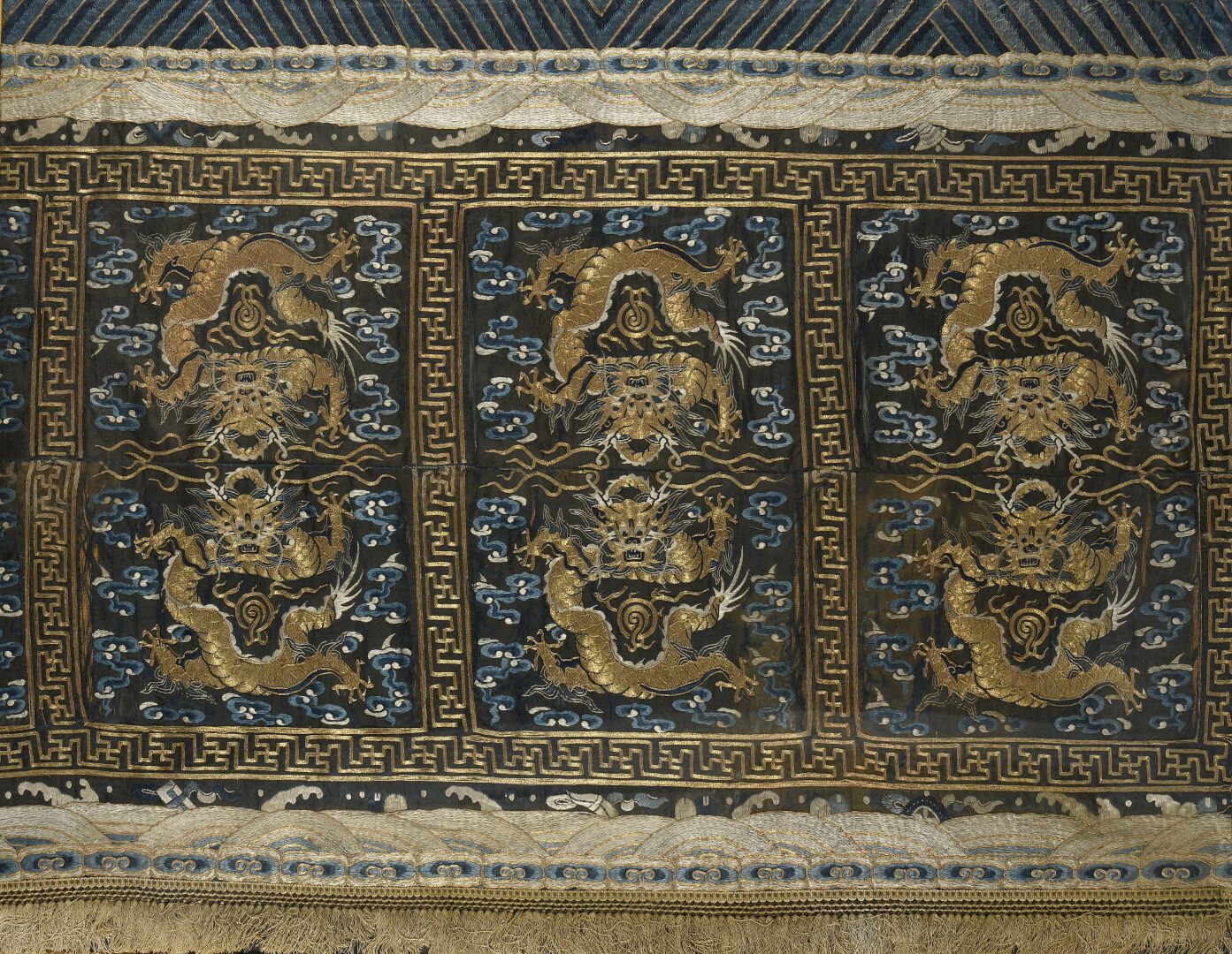 Null 绣有金色金属线的丝绸帐篷
中国，清末（1664-1911）。
三层装饰，云中有两条龙，边框上有饰物；有破损，有破损。
102 x 140 厘米