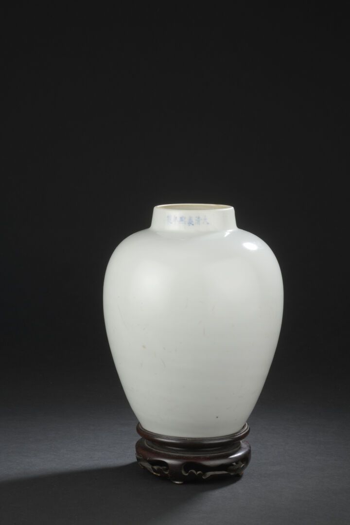 Null 白色珐琅彩瓷器花瓶
中国
卵形，顶上有短颈，带着一个蓝色的康熙伪证，木质底座；划痕、 
底部有轻微的裂纹，内部有小的星形裂纹。
H.20.7厘米