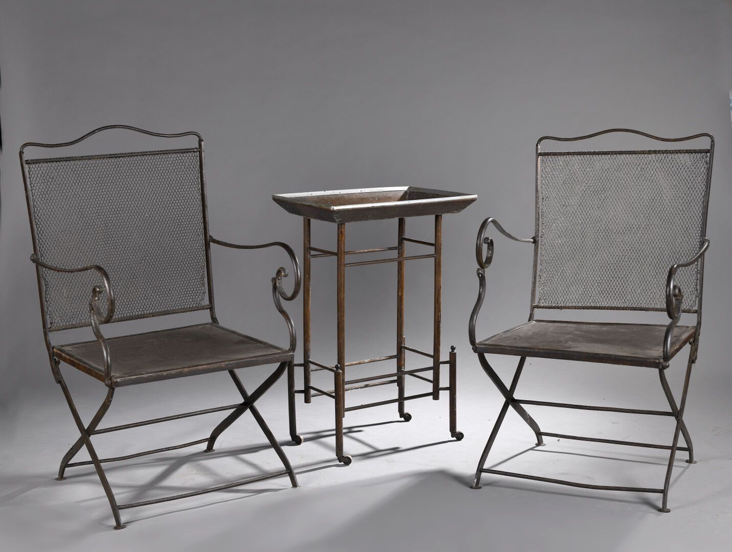 Null 一对军官椅，19世纪，金属，折叠，卷曲的扶手，铁网背。 
一个扶手松动，变形。 
97.5 x 52.5 x 52厘米。