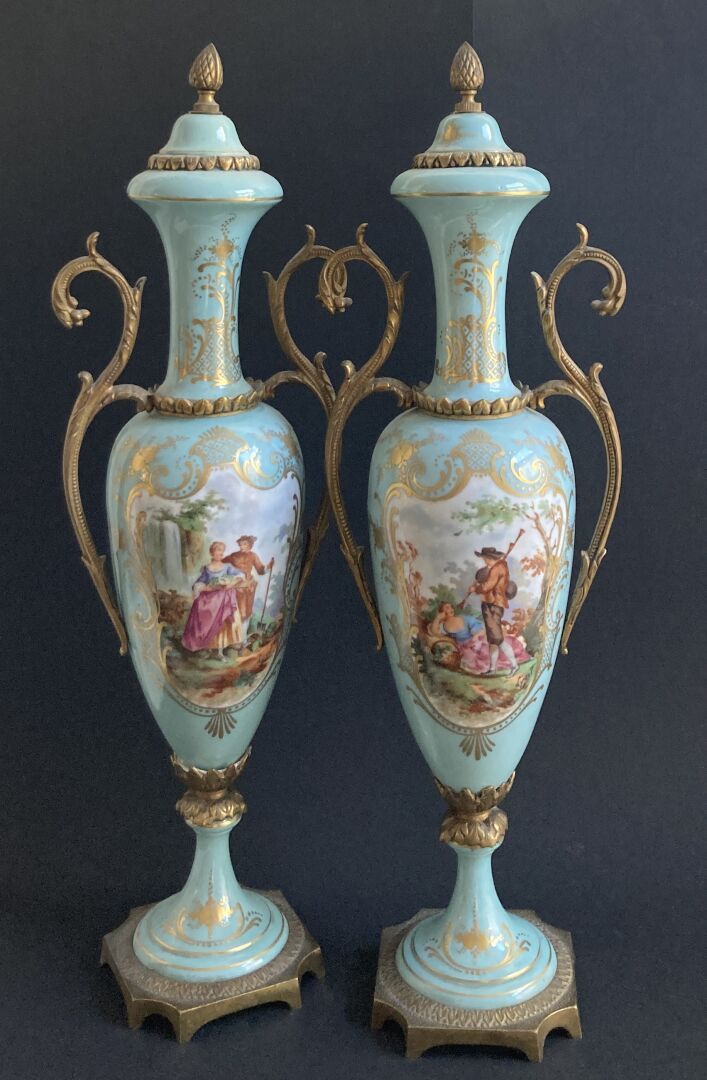 Null 塞夫勒风格： 
一对纺锤形的瓷瓶，在浅蓝色的背景上有鎏金框架的风俗场景的多色装饰。鎏金铜座。 
大约在1900年。 
背面有伪装标记。
高度：46厘米&hellip;