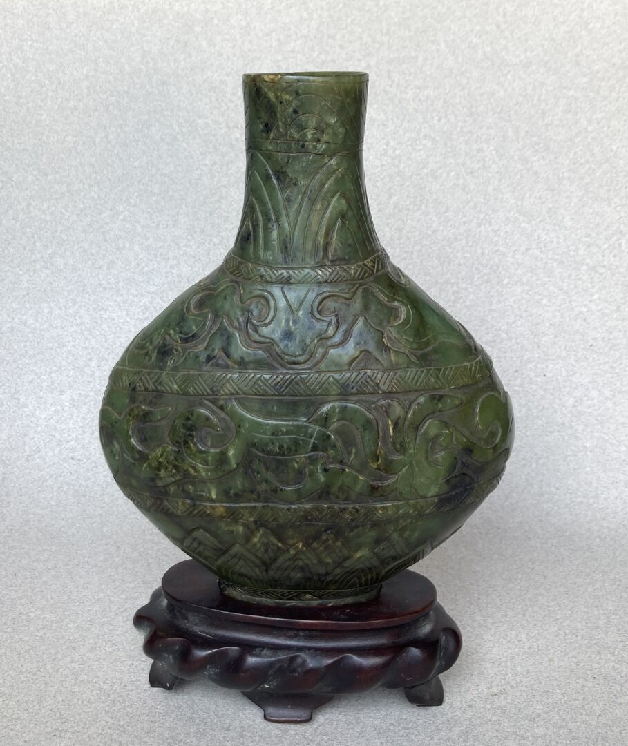 Null CHINA UM 1900
Vase aus geschnitztem grünem Nephrit und Holzsockel.
H: 22,5 &hellip;