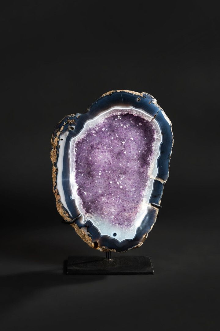 Null 紫水晶晶体镶嵌在玛瑙晶洞中。

在一个基地上展示。

总高度43厘米 - 宽度28厘米