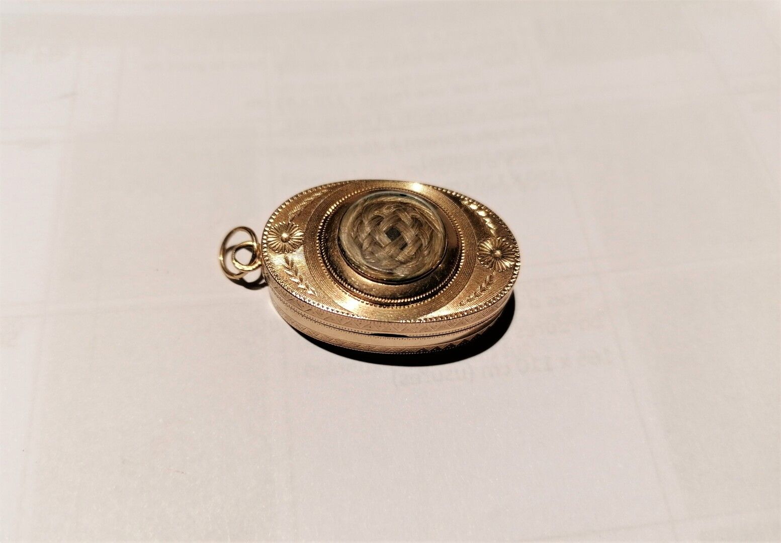 Null 
14K黄金（585毫米）的椭圆形酒壶，雕刻精细，壶盖上装饰着一绺头发。配有一个扣子。




对烤架的损害。




毛重 : 15,30 g