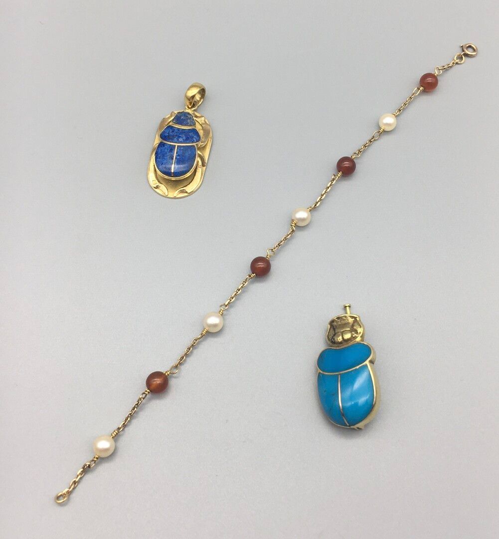 Null Lot including:

An 18K 750 yellow gold pendant in the form of a scarab, the&hellip;