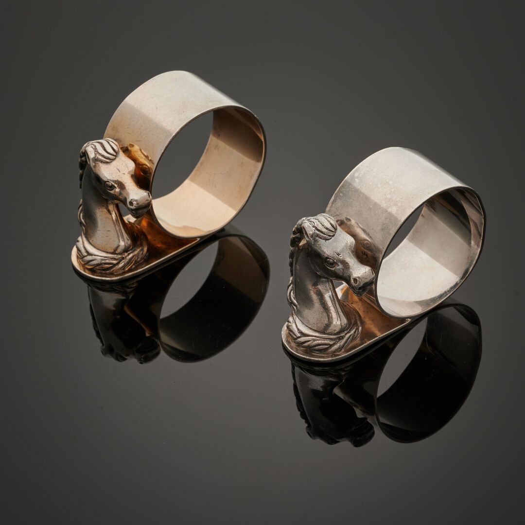 Null 爱马仕，拉维纳特-登费特设计
两个镀银金属餐巾环，饰有马头。
包括两张莲花餐垫和两张餐巾。
(有镀金和变形痕迹）