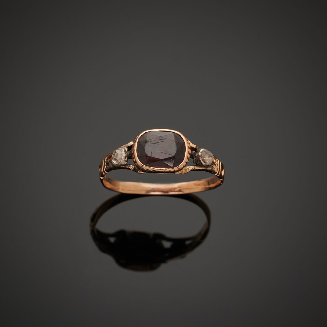 Null 一枚 18K 750‰双色金戒指，中央镶嵌一颗枕形石榴石，肩部镶嵌玫瑰式切割钻石。
手指尺寸：56
毛重：1.90 克（使用痕迹，宝石碎裂）