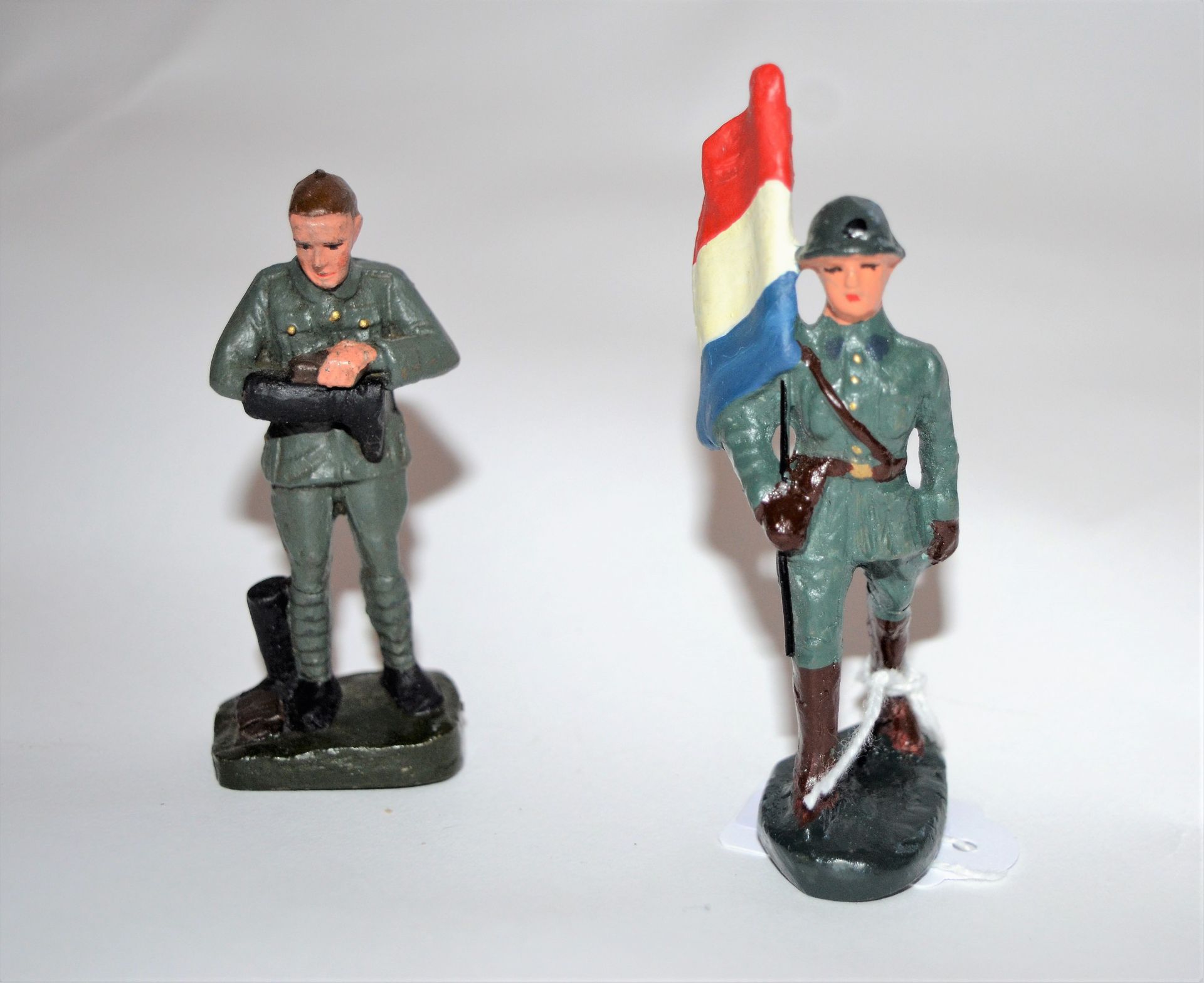 Null CLAIRON（比利时品牌，从1935年到1950年）。荷兰：2名士兵，一个举着国旗行进，另一个在擦拭靴子。 高度：7.5厘米。状况非常好。