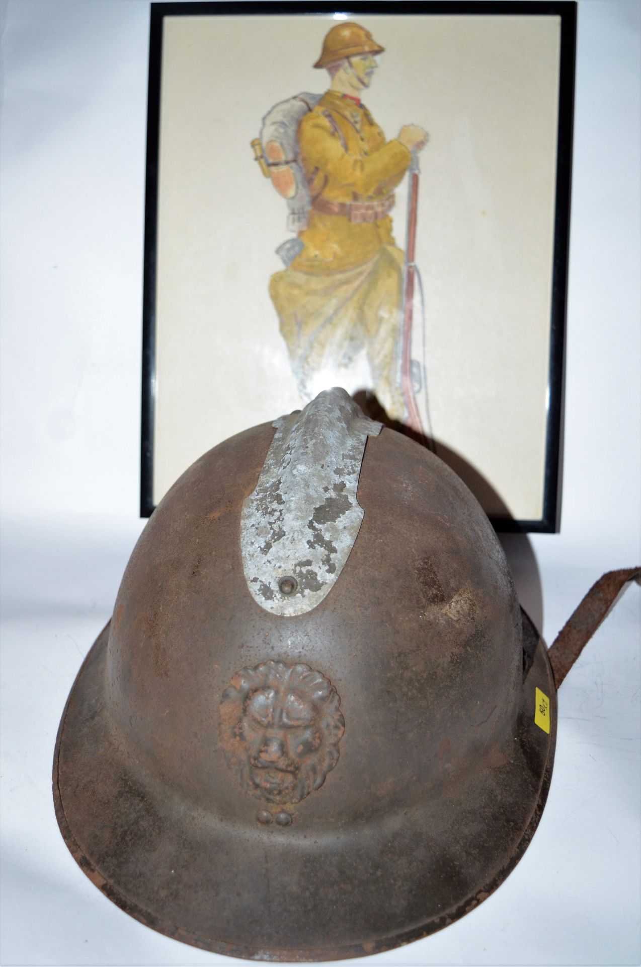 Null 军品：比利时：1个处于使用状态的阿德里安头盔（带下巴）；一幅表现手榴弹兵休息的水彩画。(23 x 30 cm out of frame)。